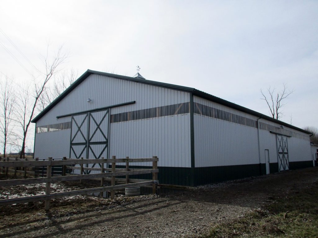Ramiro & Kirstin - South Bend, IN 60 x 104 x 16 Horse Riding Arena, and a 42 x 24 addition with horse stalls. Tack room also was built. Green roof, trim, and wainscoting, with white sides.
