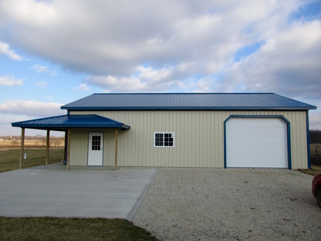 Sam - New Paris, IN 36 x 48 x 11.5 Garage with 36 x 6 wrap around porch. Blue roof, and trim with Light Stone sides.