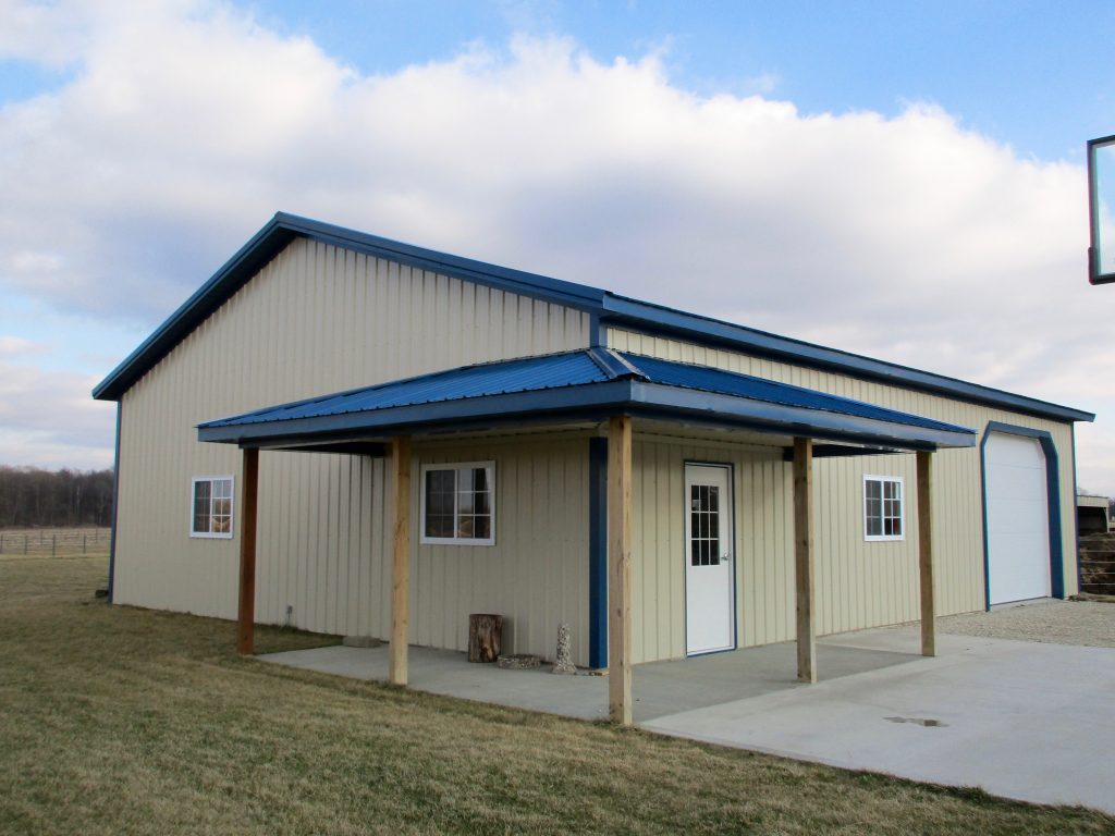 Sam - New Paris, IN 36 x 48 x 11.5 Garage with 36 x 6 wrap around porch. Blue roof, and trim with Light Stone sides.